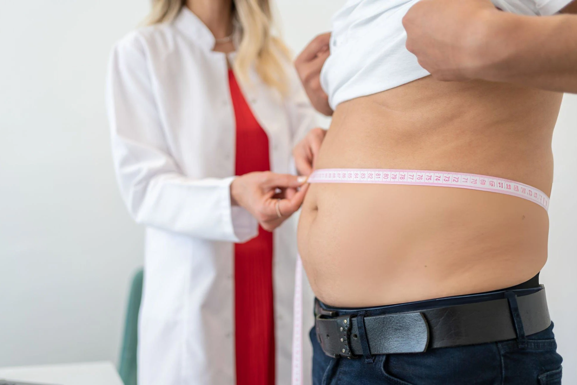 Using BMI: Everything You Need to Know Nutritionist Measuring Patient's Waist During Consultation In Office