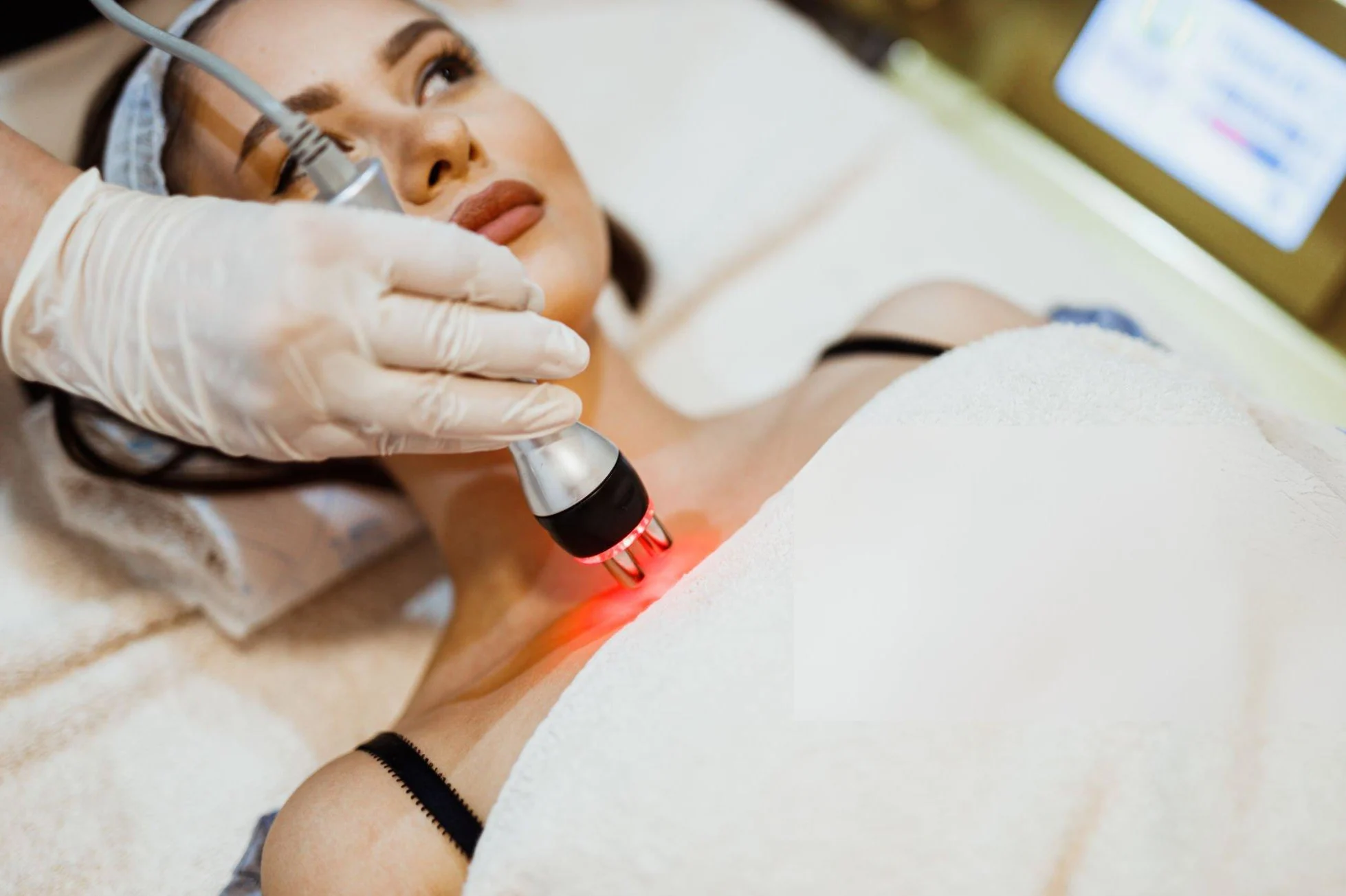 What Else Can I Use to Check Body Fat Levels? Young woman lying down in the beauty clinic and having an ultrasound cavitation treatment to lift the skin and remove body fat