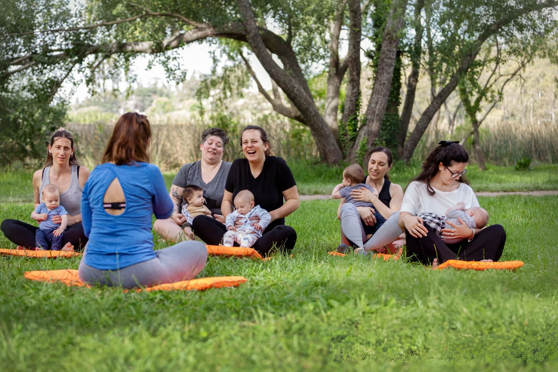 6-Week Postpartum Weight Loss Guide: Exercises & Safe Timeline Postpartum Weight Loss - Group of women exercising with their babies in the park - Yoga, stretching and meditation with their babies